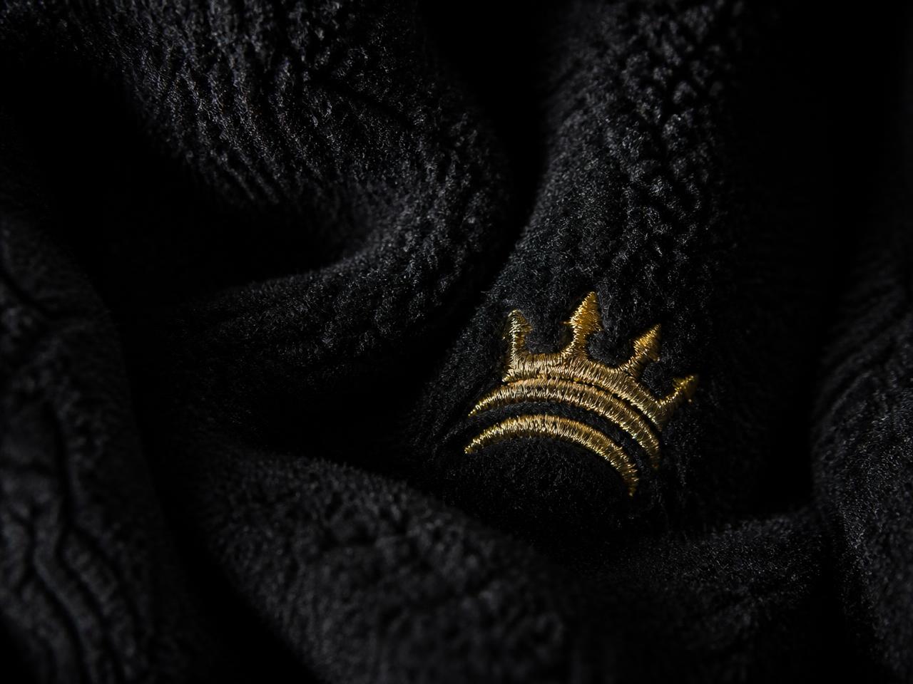 Macro detail of gold embroidered emblem on black fleece